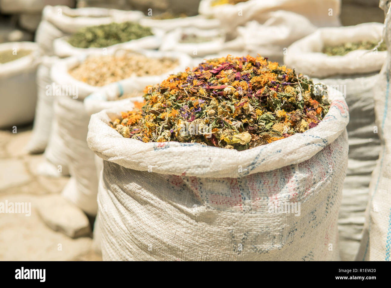 Stack of small and colorful dried flowers for sale in a sack at the bazaar. Stock Photo