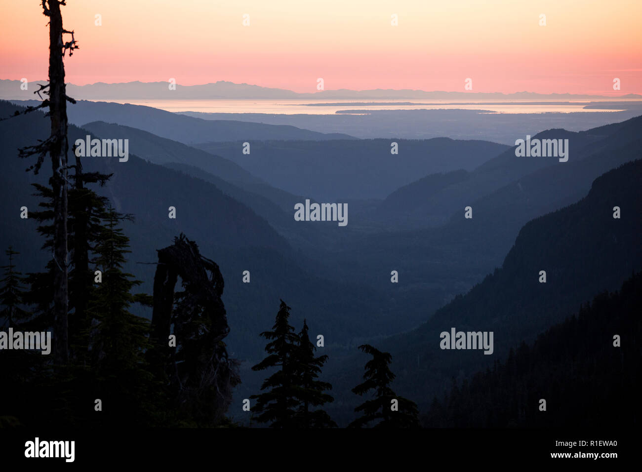 Sunset, sun set, over mountains. Sunset mountains panoramic. Colorful and scenic sunset over the Cascade Mountains. Looking towards Vancouver Island. Stock Photo
