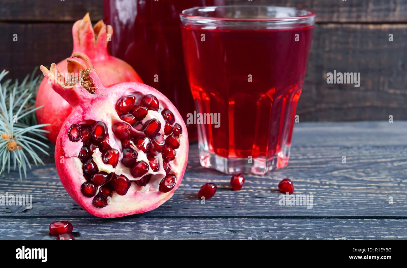 A glass of fresh pomegranate juice with ripe pomegranate fruits on