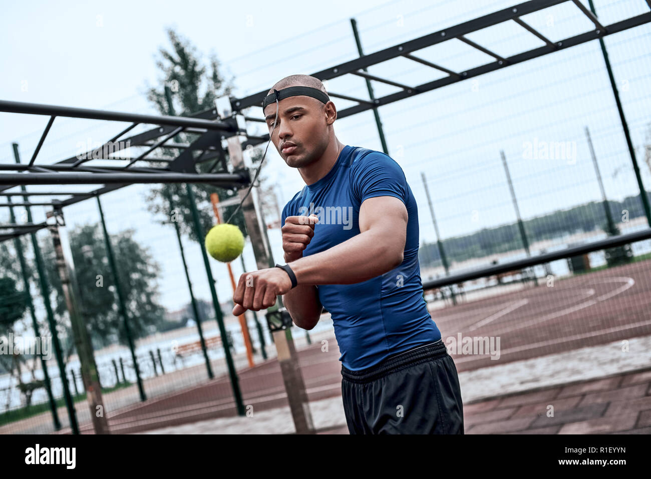 An african man is boxing with tennis ball at open air gym Stock Photo