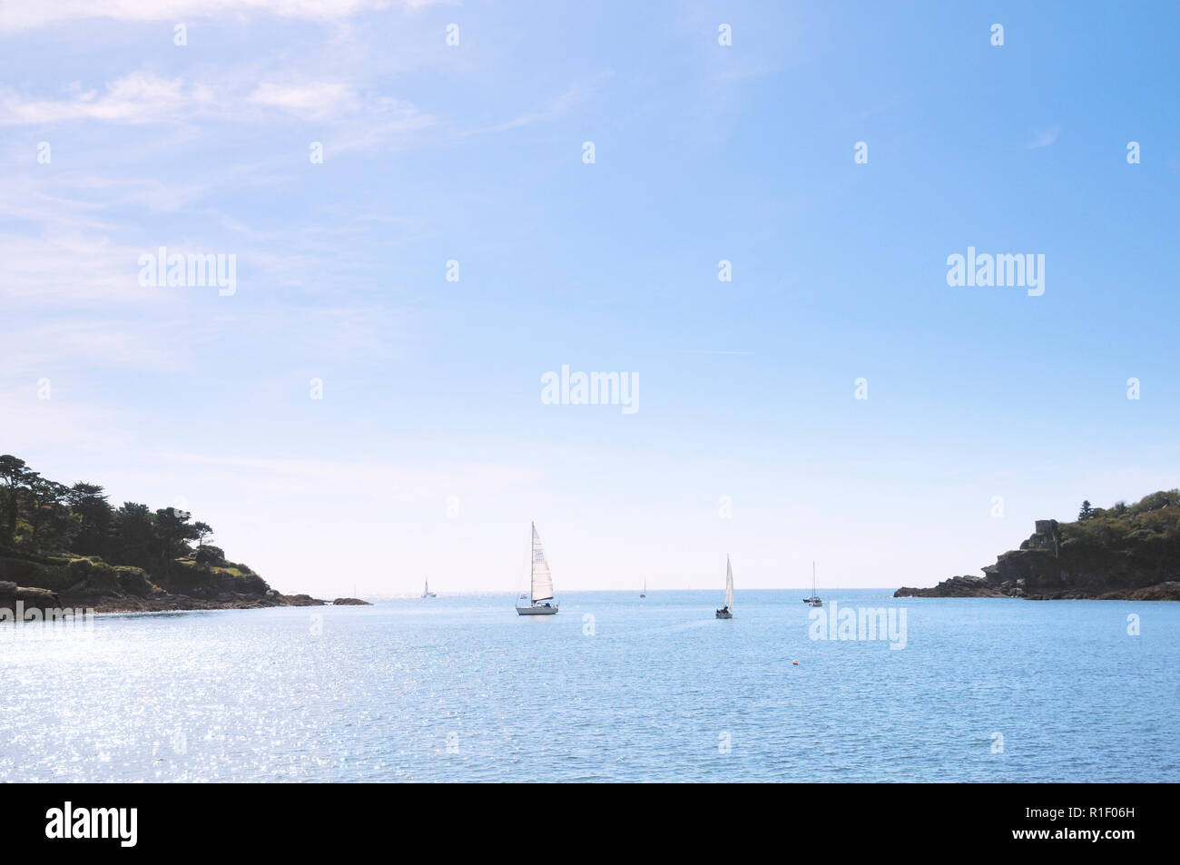 Sailing boats at the mouth of the River Fowey Estuary between Polruan and Fowey, Cornwall, England, UK Stock Photo