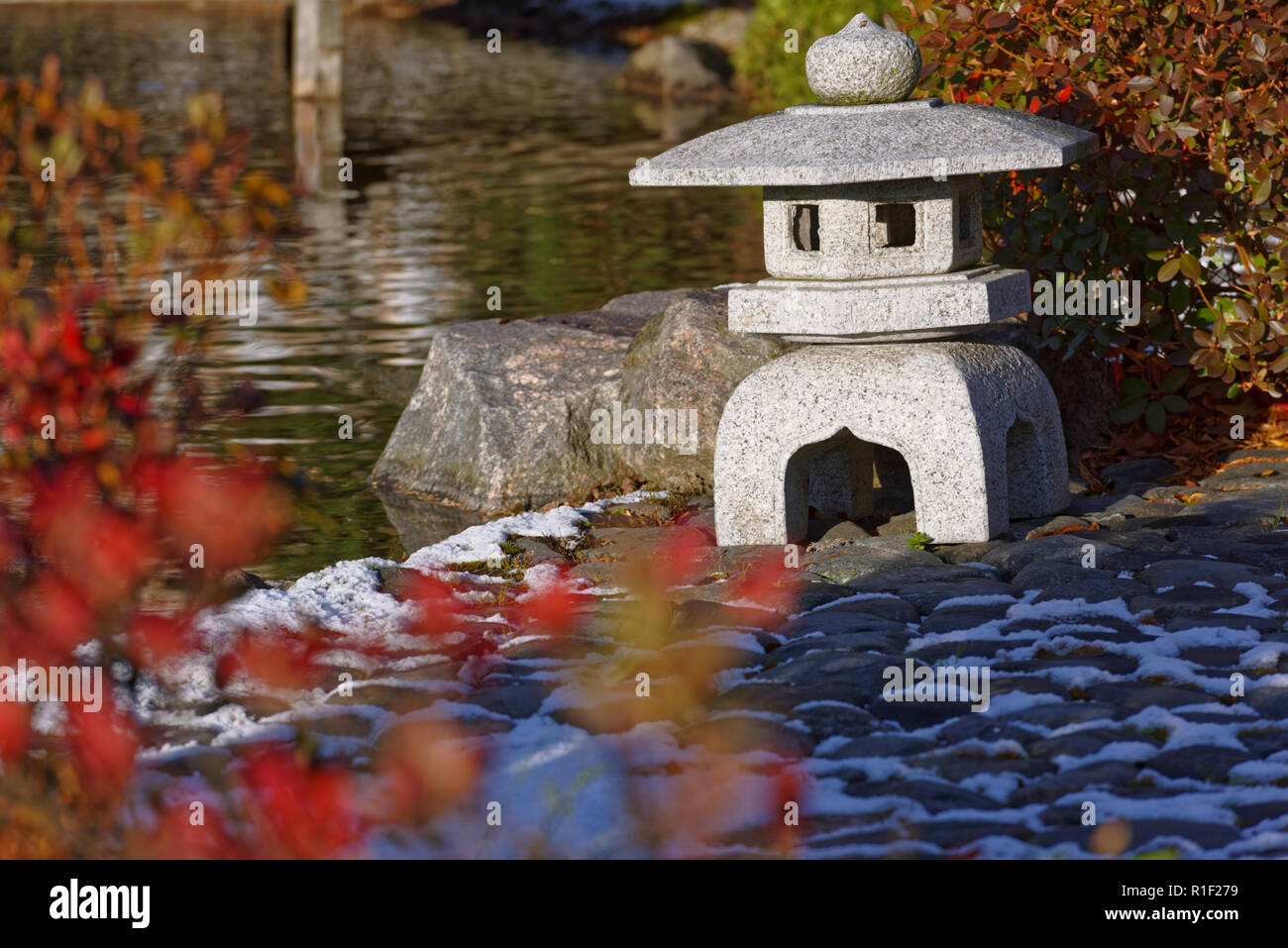 Stone Japanese lantern in autumn garden Stock Photo
