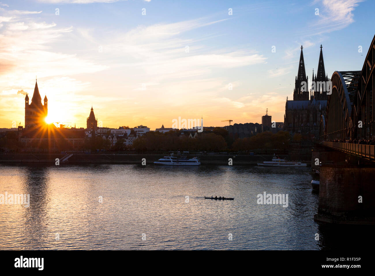 the river Rhine and the old part of the town with the romanesque church Gross St. Martin, the cathedral and the Hohenzollern bridge, sunset, Cologne,  Stock Photo