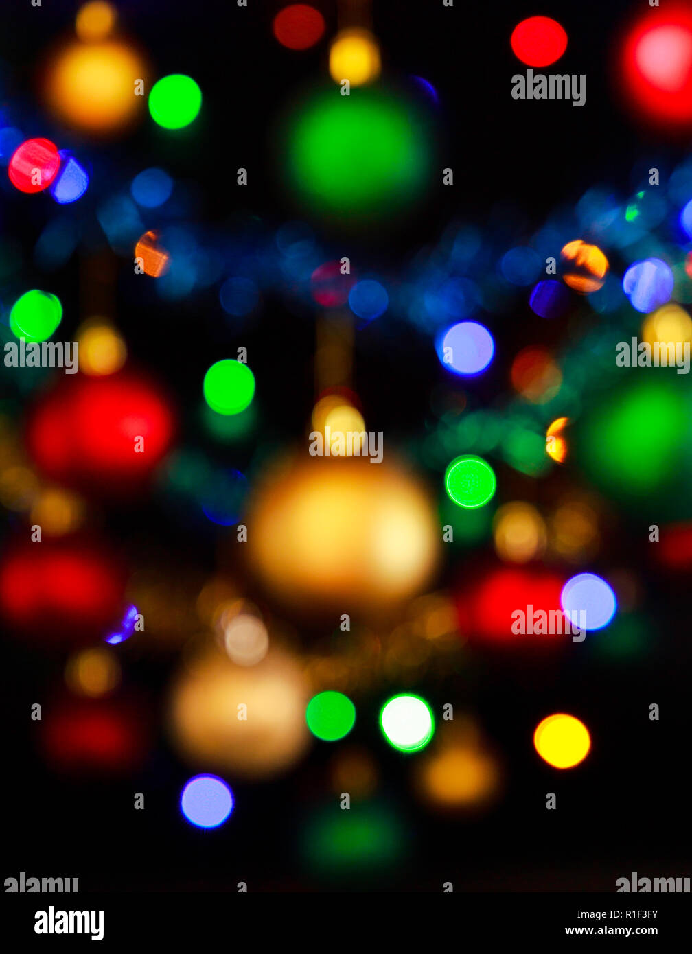 Bokeh of Christmas lights and blurred Christmas decorations with reds, greens, blues, yellows/golds and white colours. Stock Photo