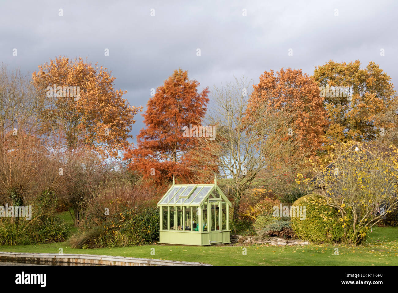 A green house in a autumn garden, England, UK Stock Photo
