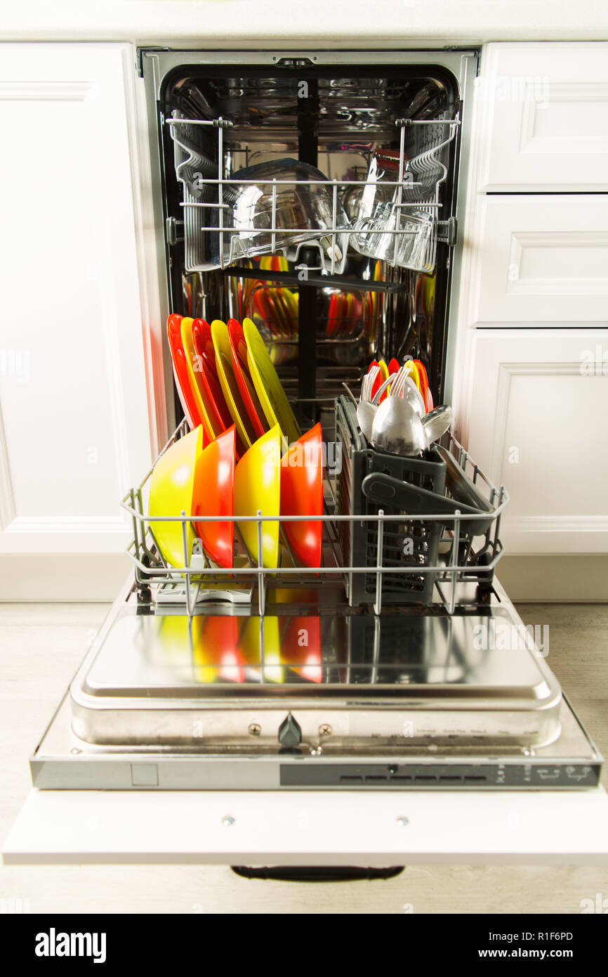 Open dishwasher with dishware after wash in the white kitchen, housework concept Stock Photo
