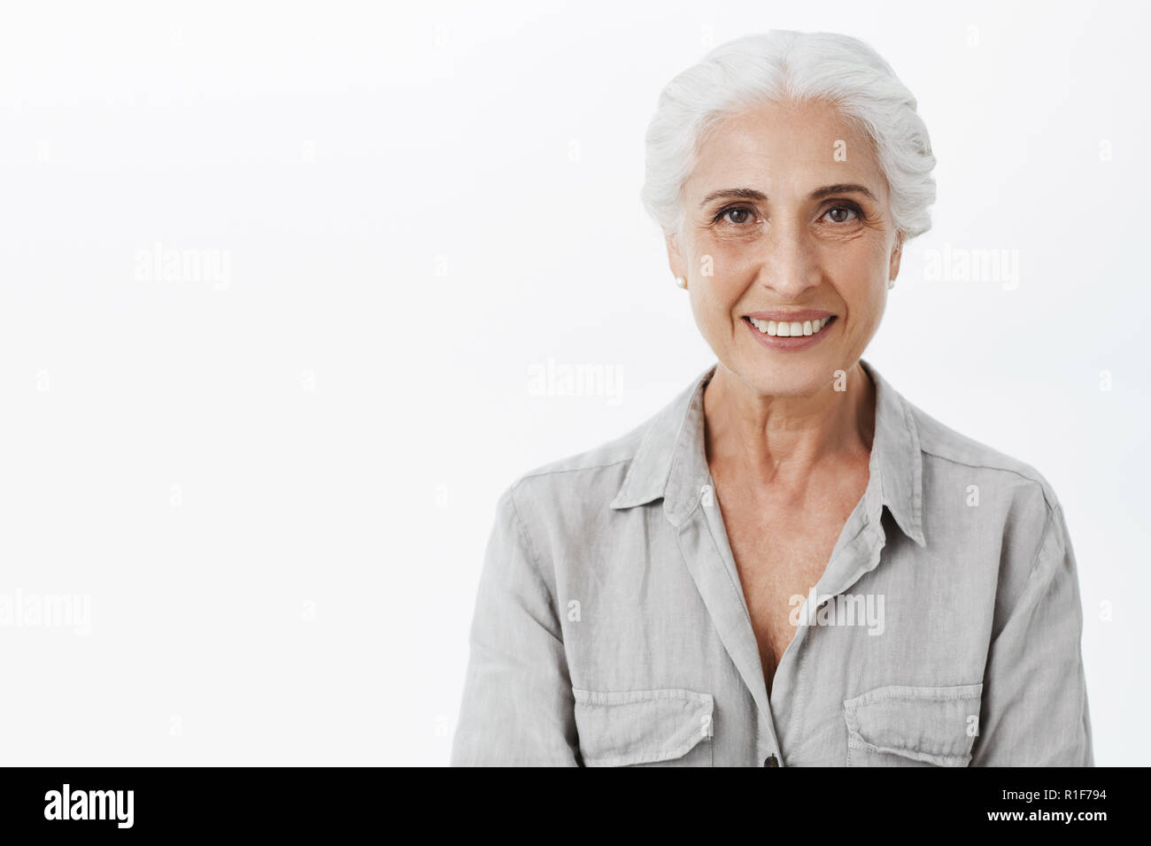 Waist-up shot of cute and kind wise elderly woman with white hair in ...