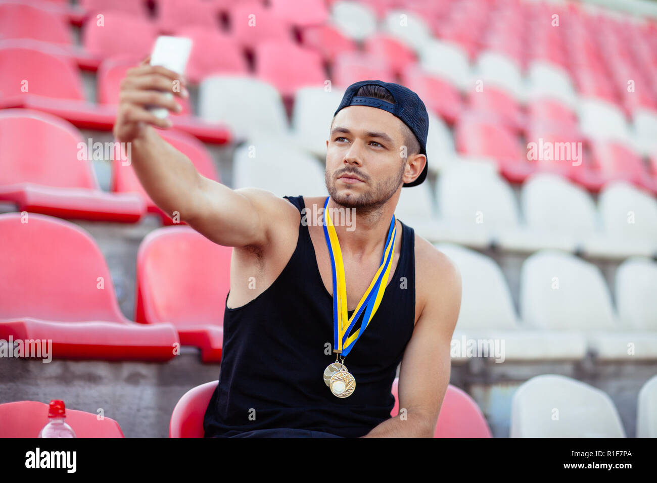 Proud winner with medals making selfie. Champion takes moment of triumph. Victory concept Stock Photo