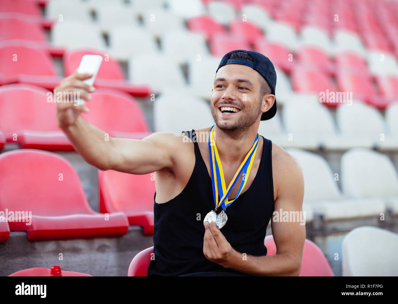 Winner with medals making selfie. Champion takes moment of triumph. Victory concept Stock Photo