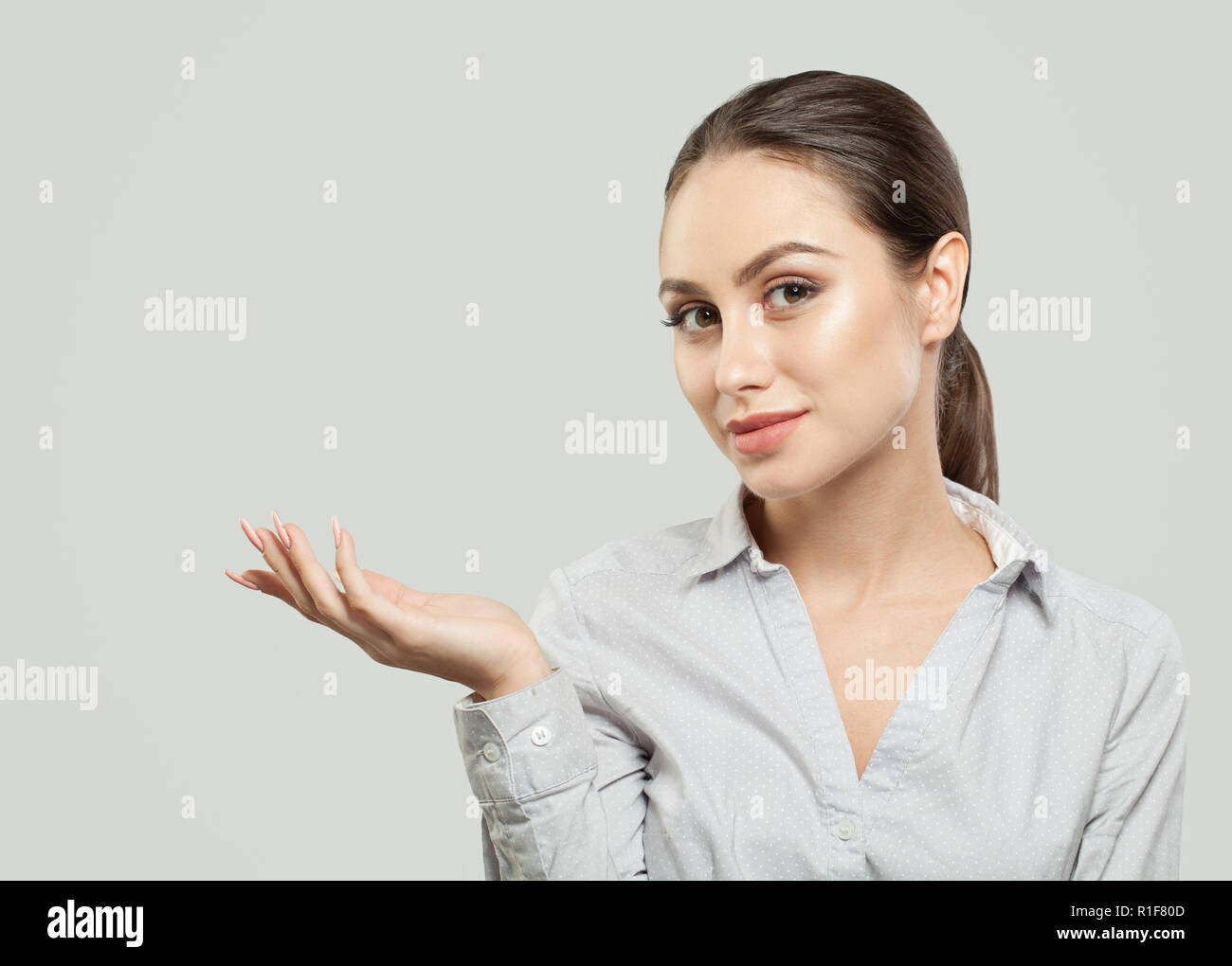 Young woman showing empty copy space on the open hand on white ...