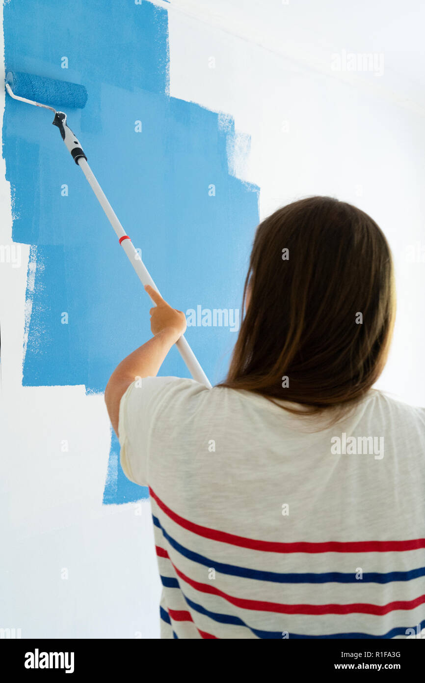Woman painting wall Stock Photo - Alamy