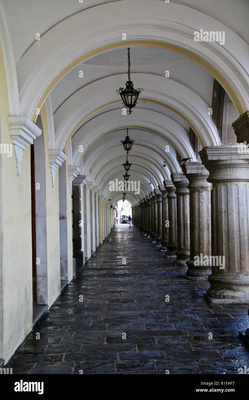 A romantic pale yellow and white elegant arched walkway with hanging metal lamps Stock Photo