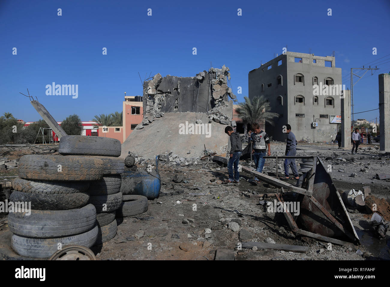 Palestinian children inspecting the effects of the Israeli shelling of the Makaniki workshop in Khan Younis. The israeli air force carried out air strike in the Southern Gaza strip area of Khan Younis on the night of 11 Nov causing damages to the building and human casualties. Stock Photo