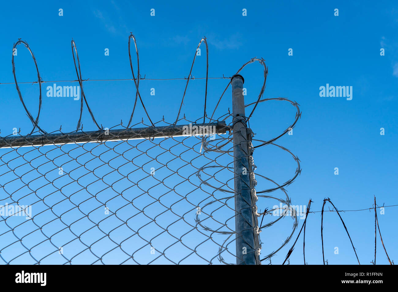 barbed wire fence on blue sky background Stock Photo - Alamy