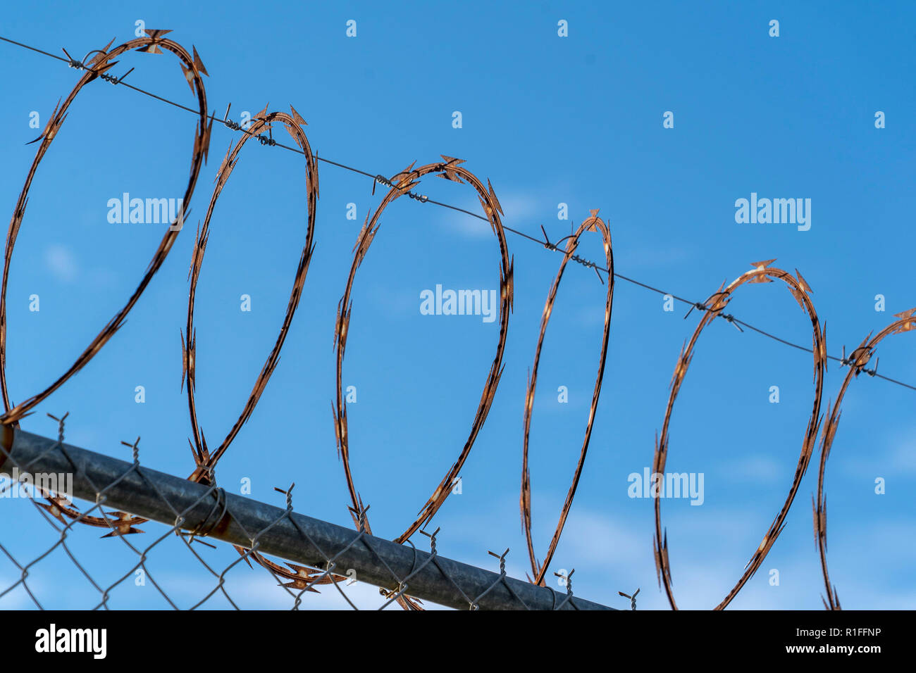barbed wire fence on blue sky background Stock Photo - Alamy