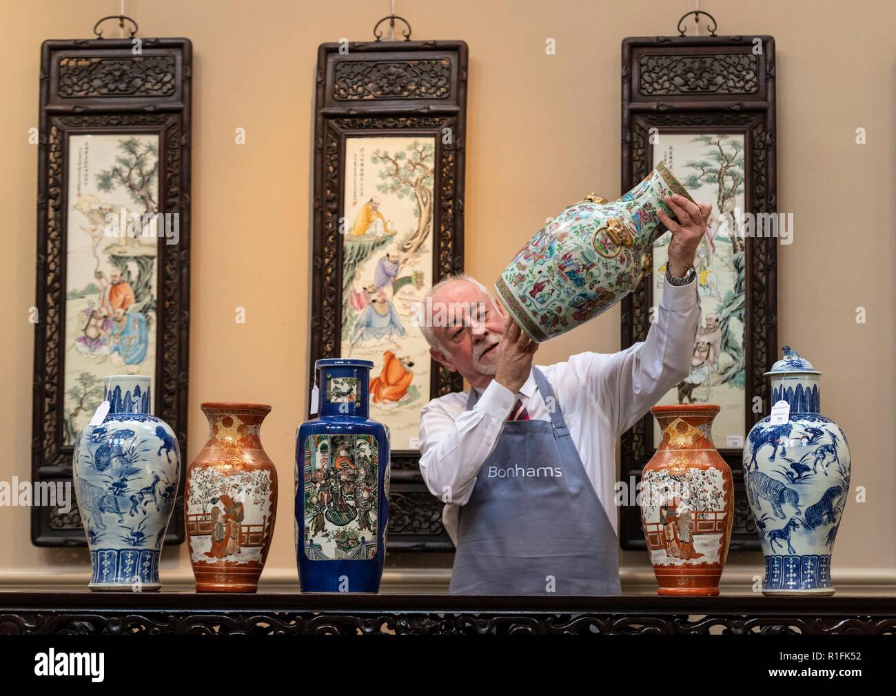 Edinburgh, UK. 12th Nov, 2018. The Bonhams Asian Art Sale takes place on Thursday 15 November at 22 Queen Street Edinburgh starting at 11 am. It features Japanese and Chinese Art including: bronzes, jades, snuff bottles, porcelain, textiles, lacquer, paintings and furniture. Pictured: Danny McIlwraith of Bonhams examining a Famille Rose Vase Credit: Rich Dyson/Alamy Live News Stock Photo