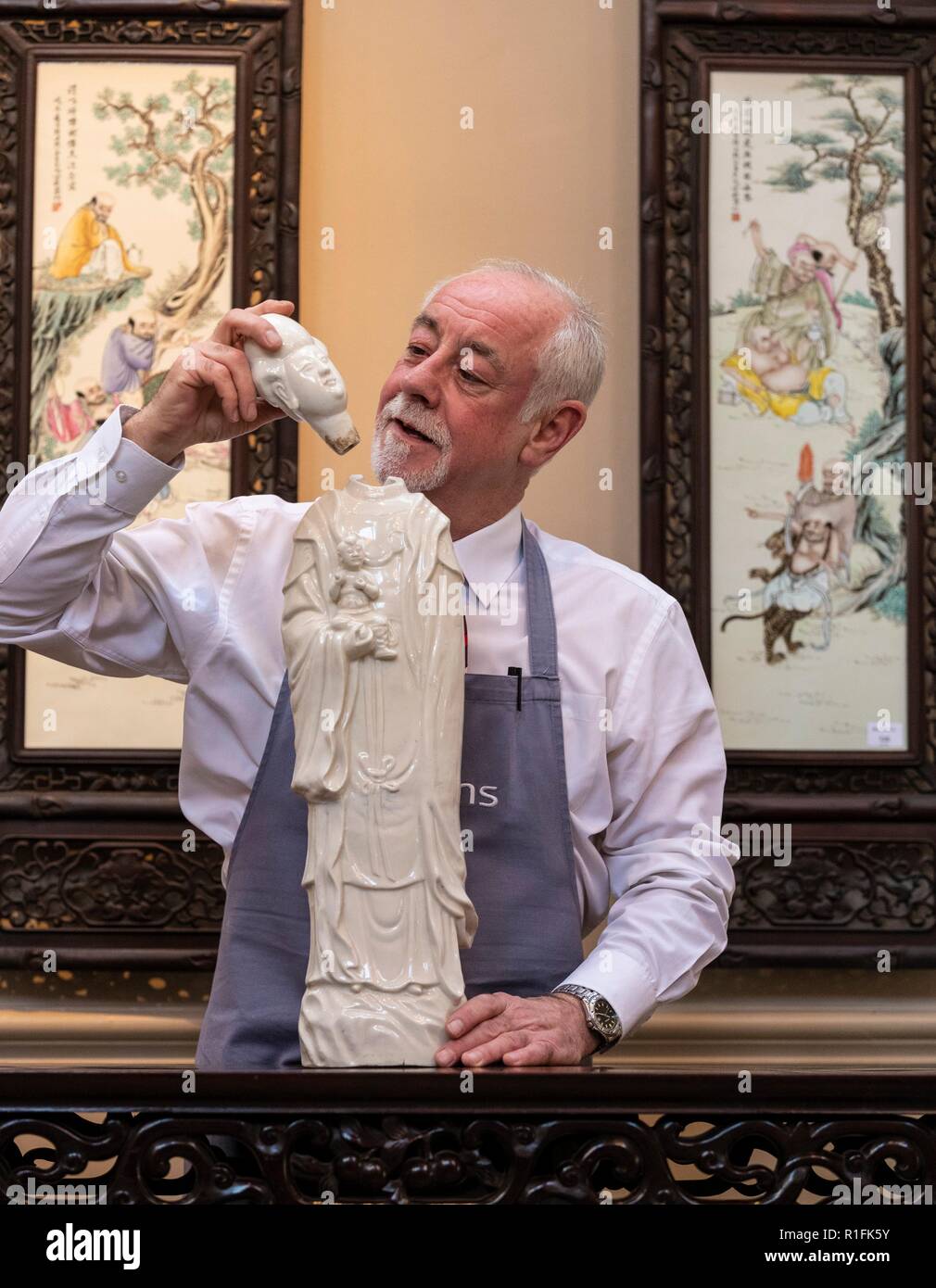 Edinburgh, UK. 12th Nov, 2018. The Bonhams Asian Art Sale takes place on Thursday 15 November at 22 Queen Street Edinburgh starting at 11 am. It features Japanese and Chinese Art including: bronzes, jades, snuff bottles, porcelain, textiles, lacquer, paintings and furniture. Pictured: Danny McIlwraith of Bonhams holding a tall Blanc-De Chine figure of Guanyin and Boy valued between £600 and £800 Credit: Rich Dyson/Alamy Live News Stock Photo