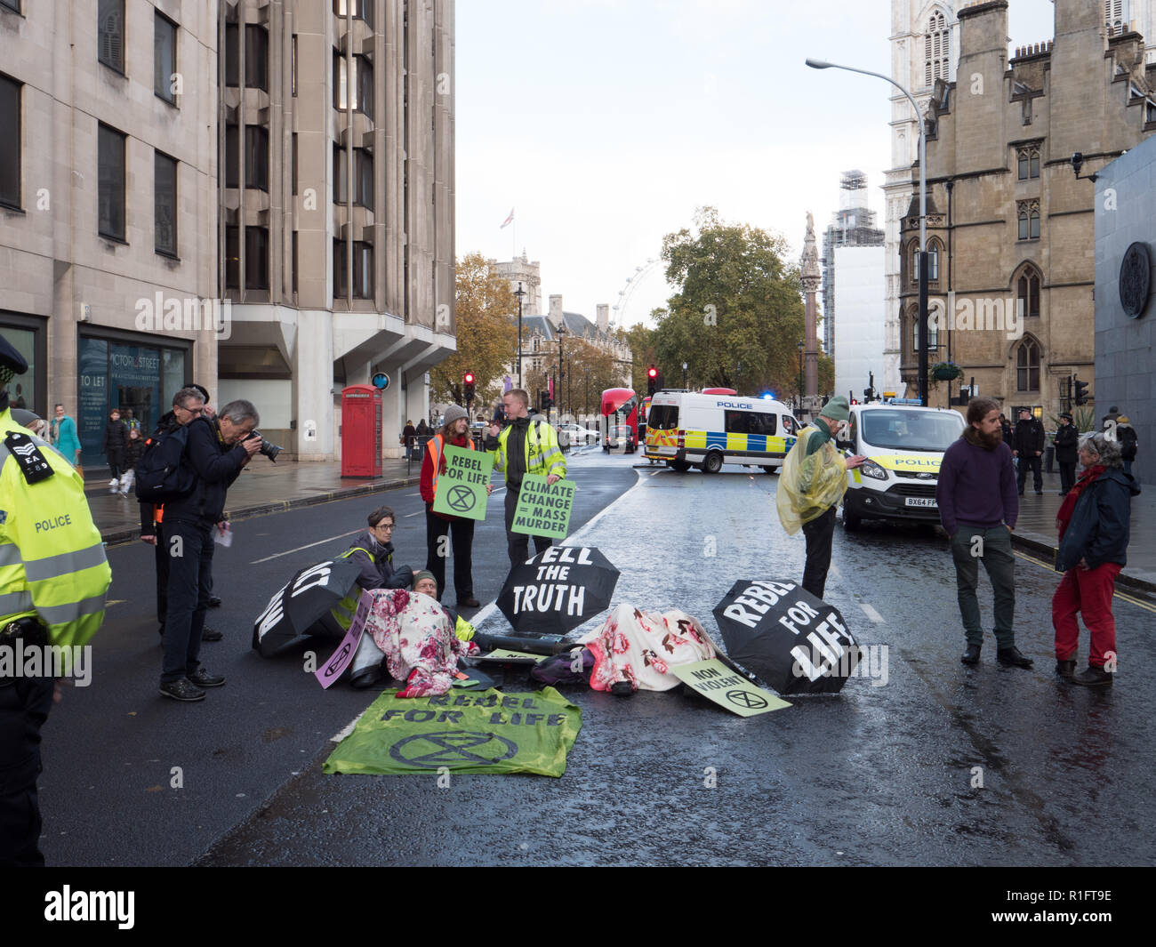 London, UK. 12th November 2018. Protesters of Extinction Rebellion holding a peaceful demonstration in front of the Department for Business, Energy & Industrial Strategy. Police have closed part of Victoria Street. Some protesters, chained to each other with a plastic tube, laying in the middle of the road. Credit: Joe Kuis / Alamy Live News Stock Photo