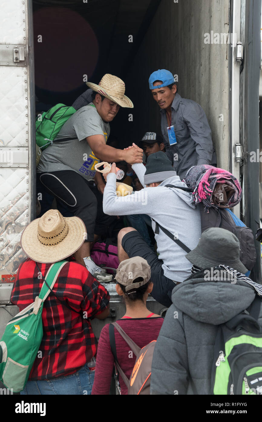 Irapuato, Guanajuato, Mexico. 12th Nov 2018. Honduran refugees with the Central American migrant caravan climb onto a tractor trailer truck after the driver volunteered to help them continue the journey northwest toward the U.S. border November 12, 2018 in Irapuato, Guanajuato, Mexico. The caravan has been on the road for a month is half way along their journey to Tijuana. Credit: Planetpix/Alamy Live News Stock Photo