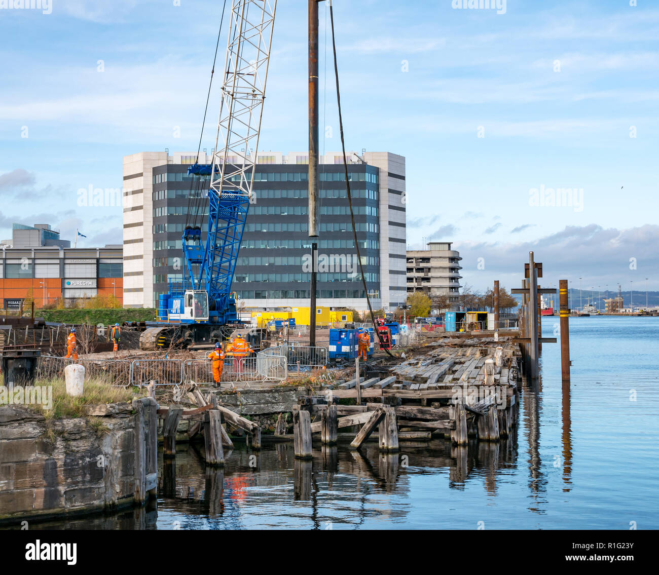 Workmen on Skyliner construction site by S1 developemnts with crane, Leith harbour, Edinburgh, Scotland, UK Stock Photo