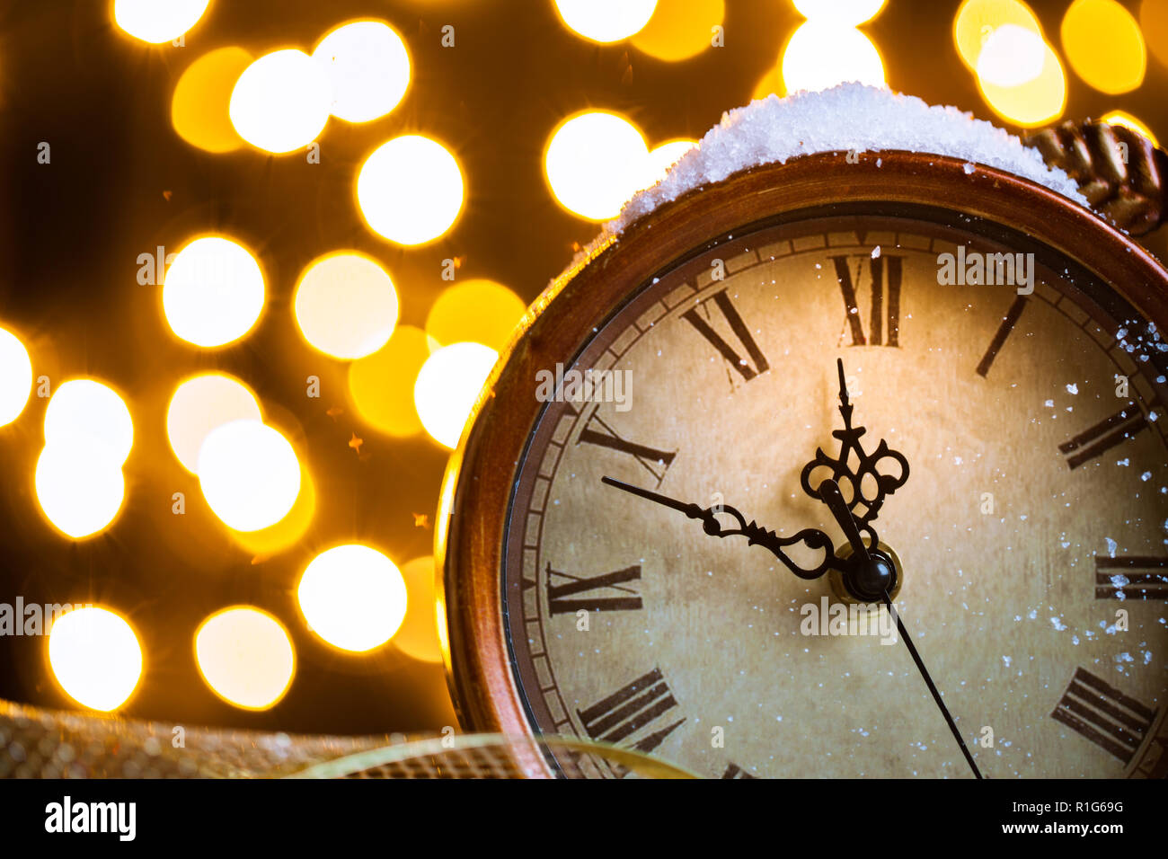 New Years clock and fir branches covered with lights Stock Photo