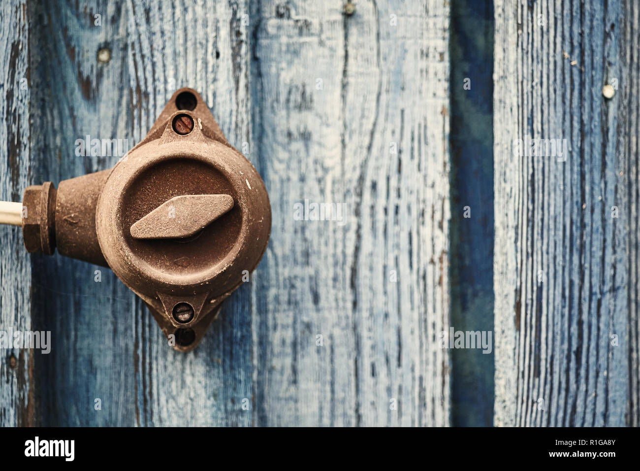 Retro toned picture of an old switch on wooden wall, selective focus, color toning applied. Stock Photo