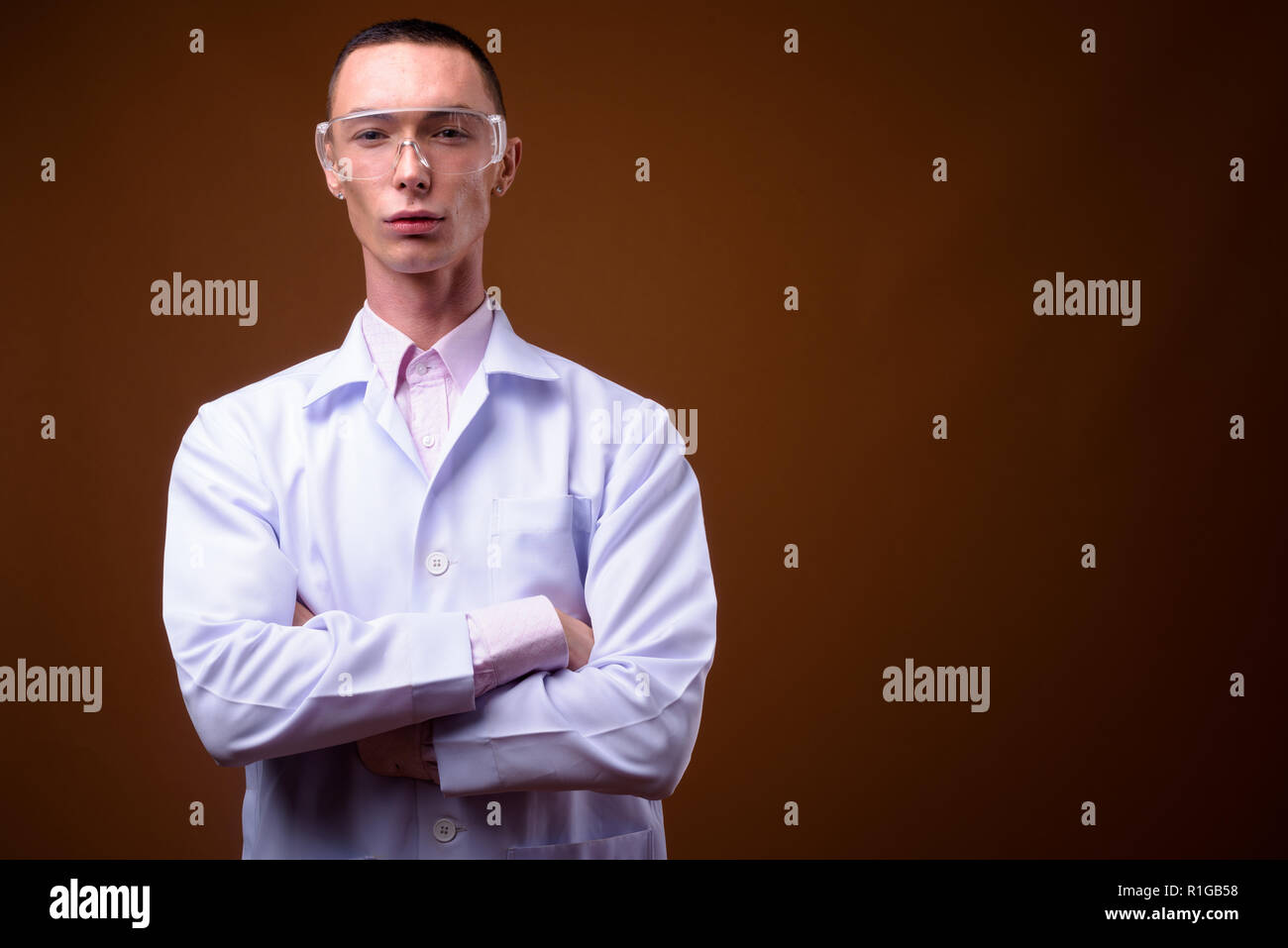 Young handsome androgynous man doctor wearing protective glasses Stock Photo
