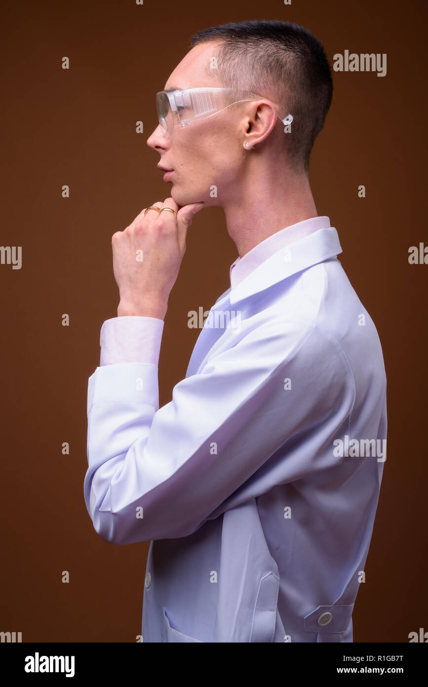 Young handsome androgynous man doctor wearing protective glasses Stock Photo