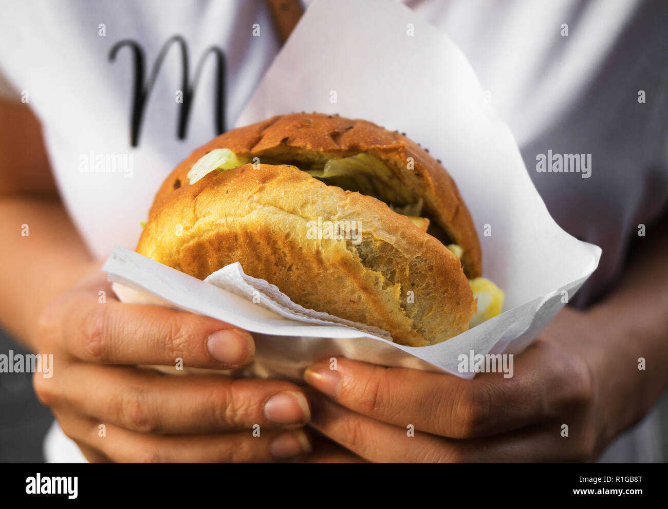 Woman hands holding a hamburger. Stock Photo