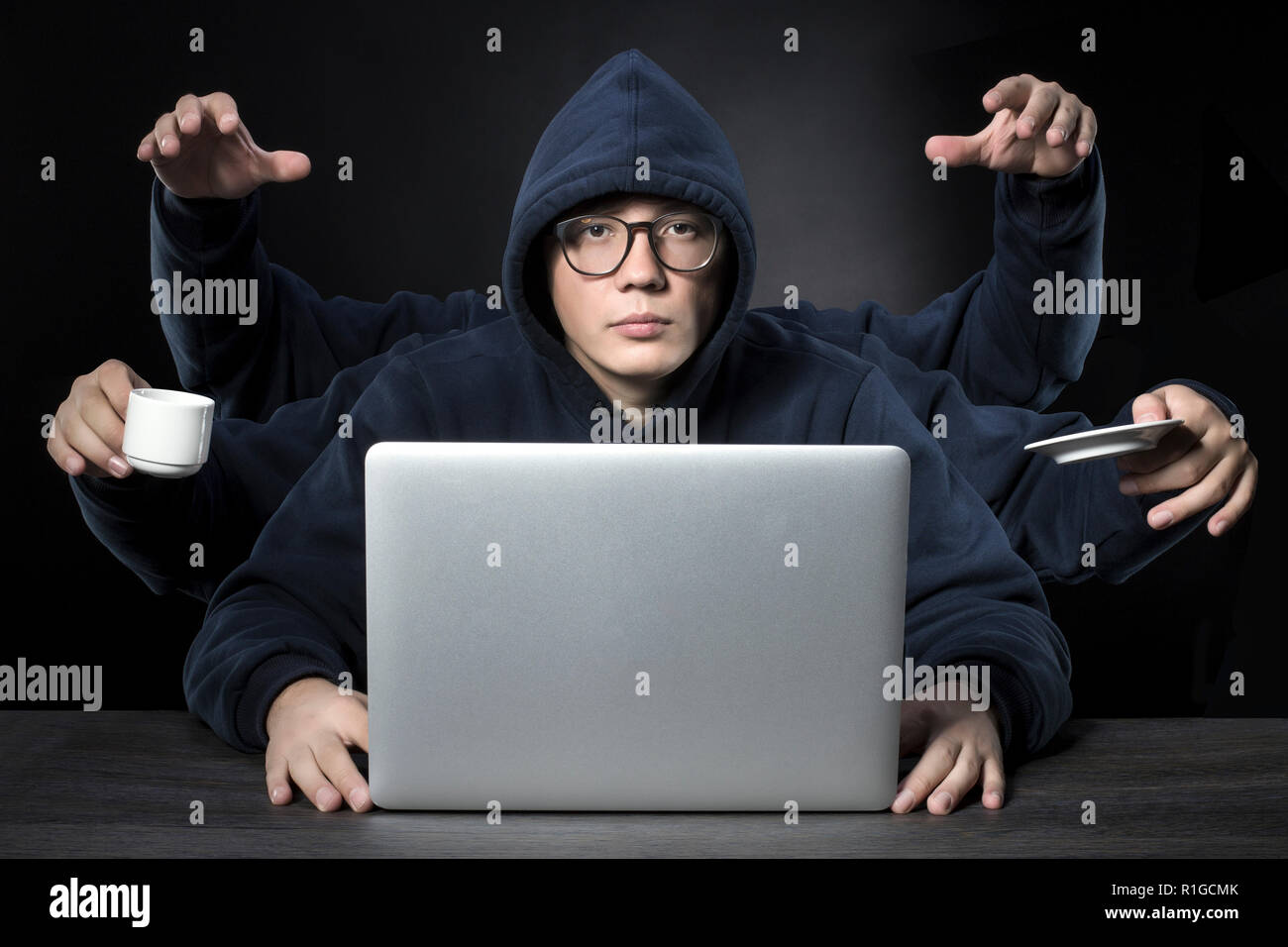a programmer with six hands all a successful workaholic in the workplace Stock Photo
