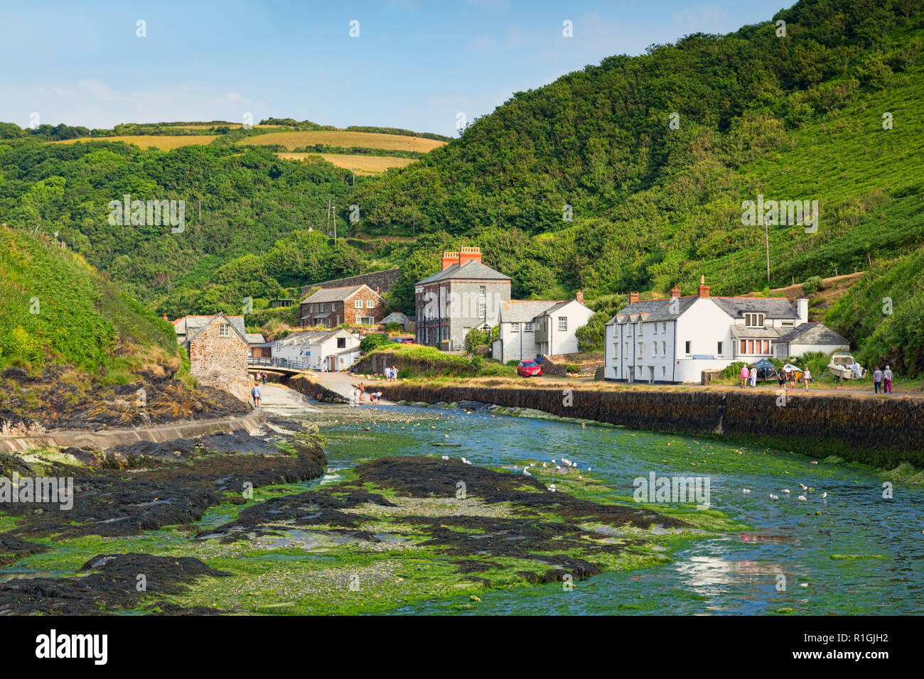 2 July 2018: Boscastle, Cornwall, UK - Visitors stroll around the village in its wooded valley, with the River Valency at low tide. Stock Photo