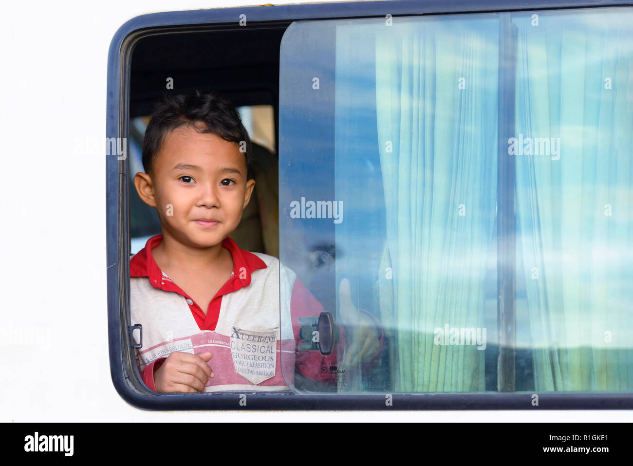 Phnom Penh, Cambodia - December 30, 2018: A cute little boy looking out of the window of his car in the street of Phnom Penh, the Cambodian capital Stock Photo