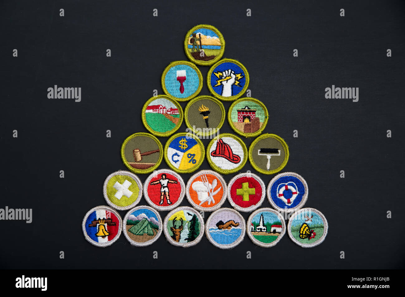 SAINT LOUIS, UNITED STATES - AUG 22, 2018:  A pyramidal arrangement of Boy Scouts of America (BSA) merit badges on black background Stock Photo