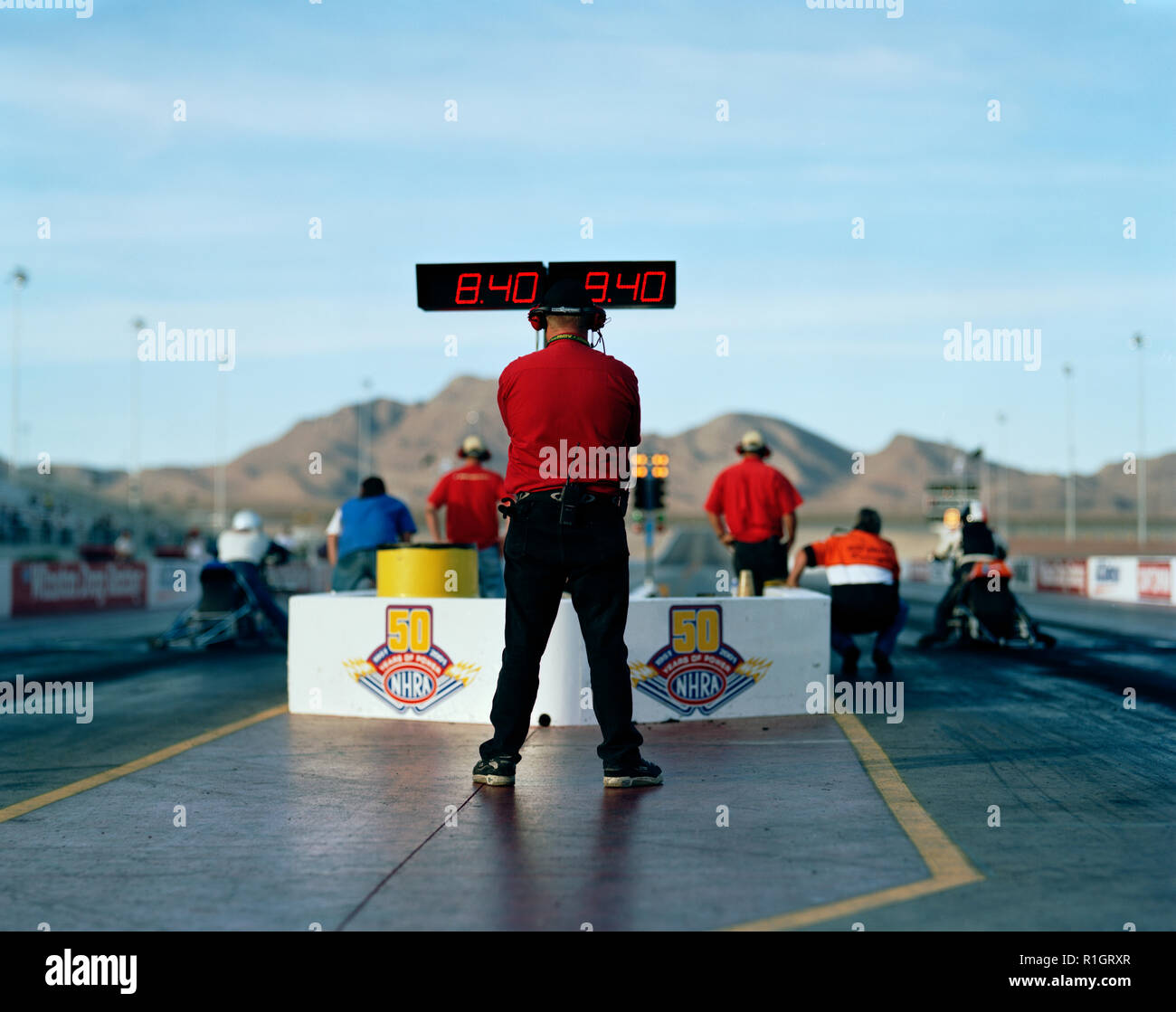 Race official standing in front of a digital time clock at an outdoor