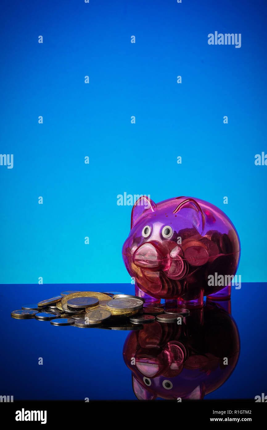 Saving concept with mason jar,coins and piggy bank on a blue background. Stock Photo