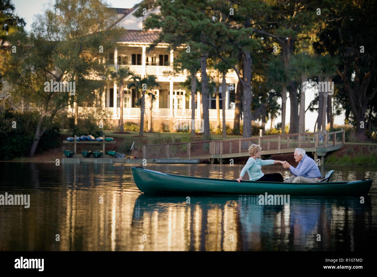 Happy senior couple holding hands while in a canoe. Stock Photo