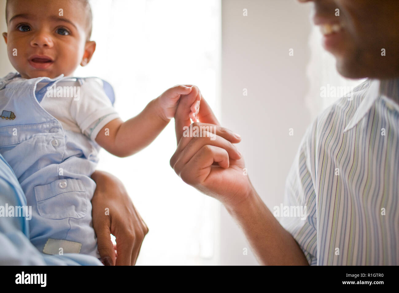Father holding hands with his young son. Stock Photo
