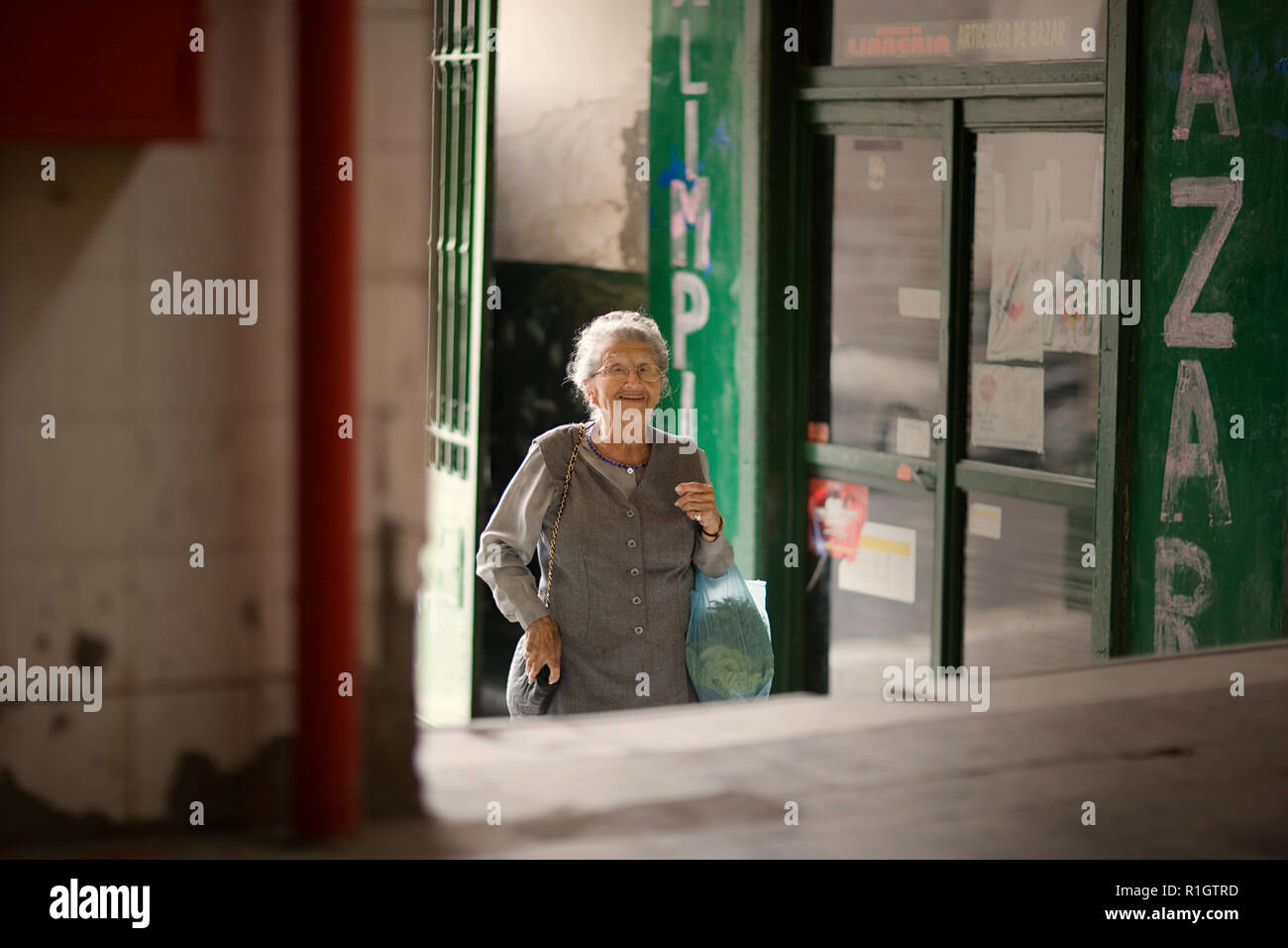 An elderly woman is entering a building. Stock Photo