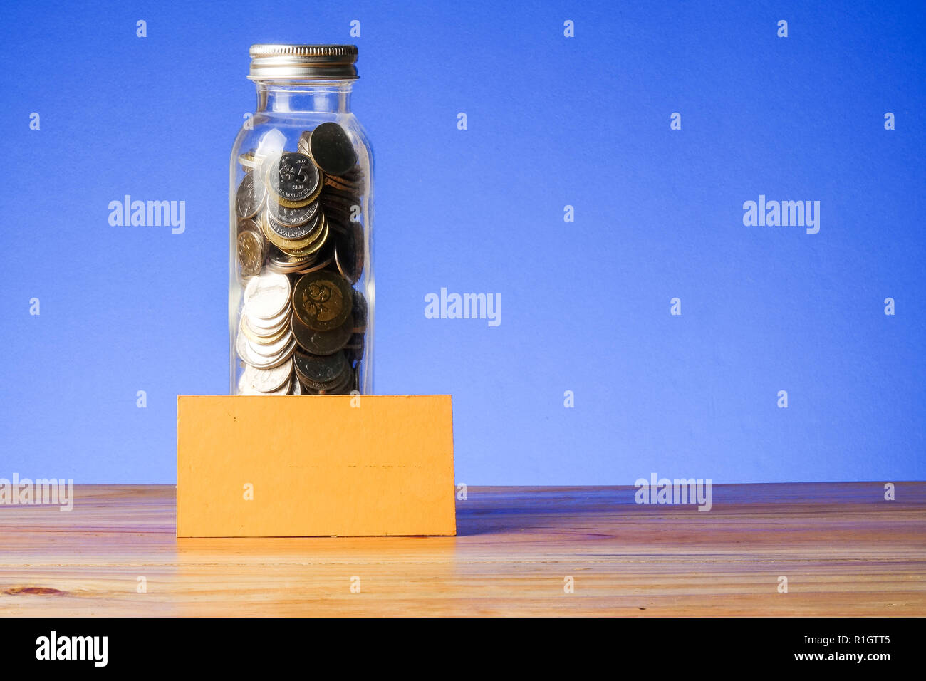 Saving concept with mason jar,coins and piggy bank on a blue background ...