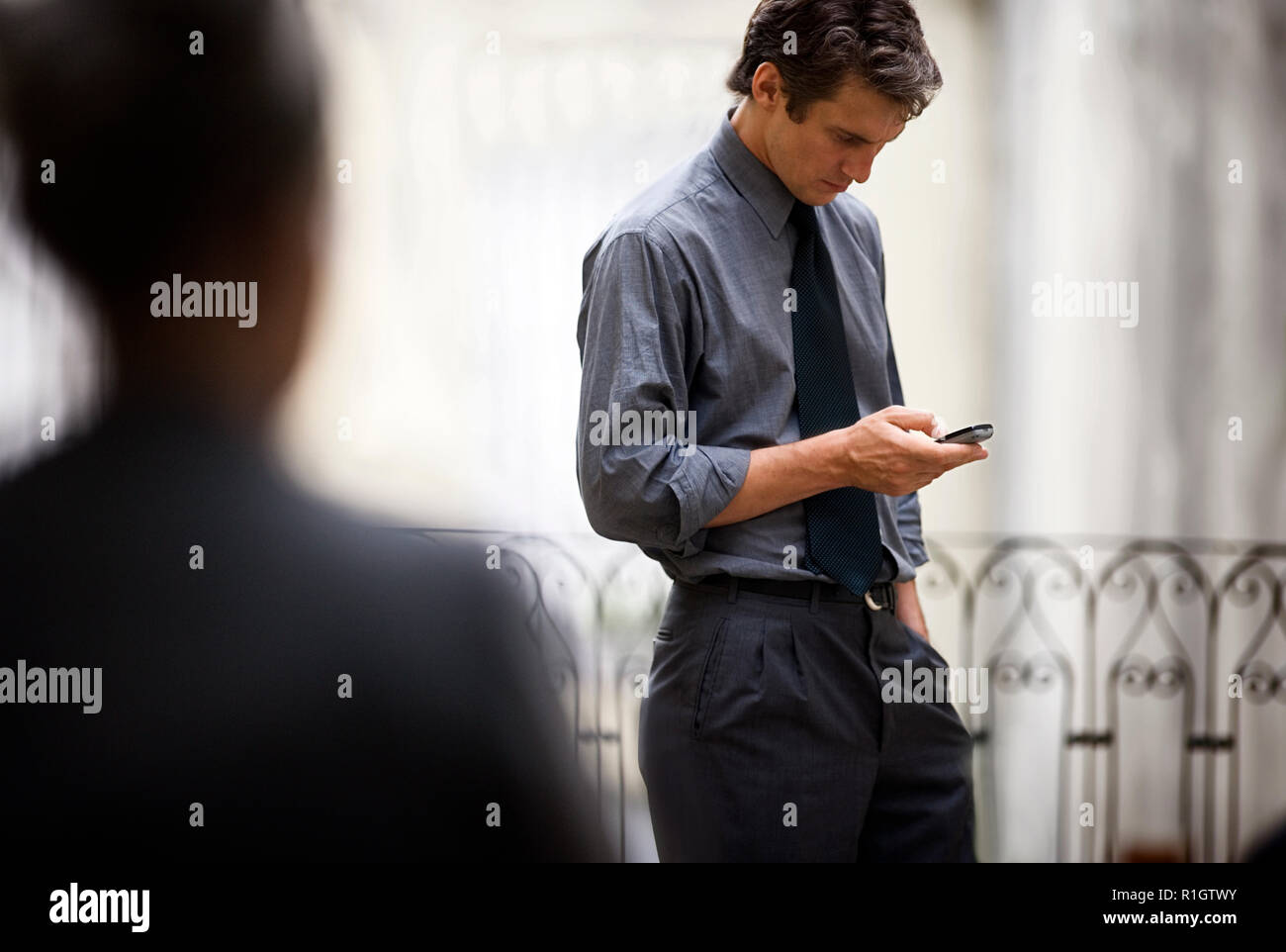 Side view of a man busy with his phone. Stock Photo