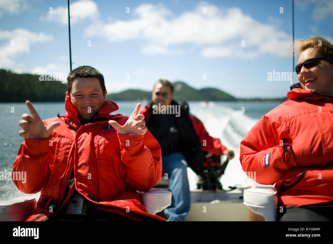 Teenage boy on a fishing boat with his mid-adult parents. Stock Photo