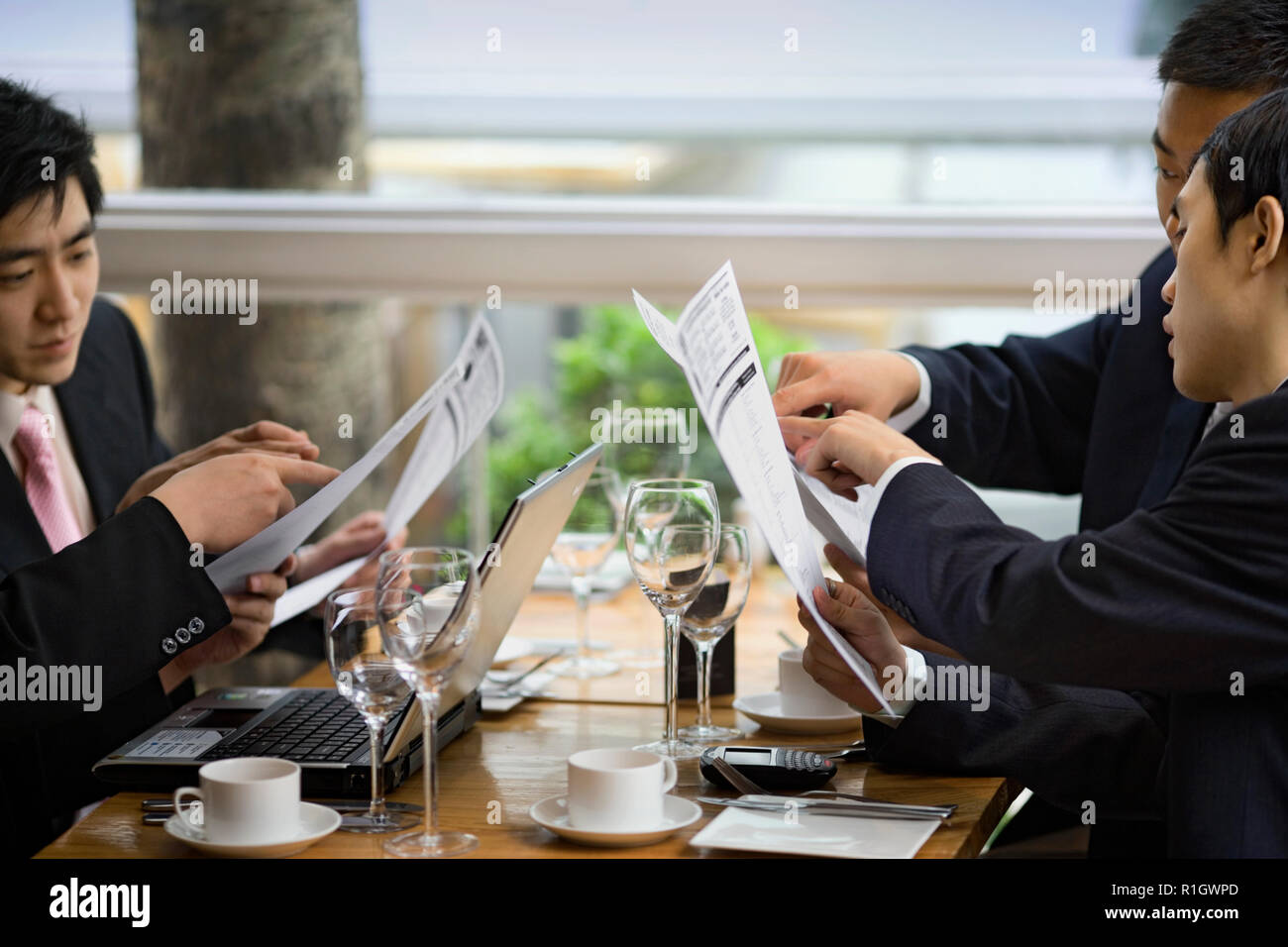 Young adult businessmen reading a menu in a restaurant. Stock Photo