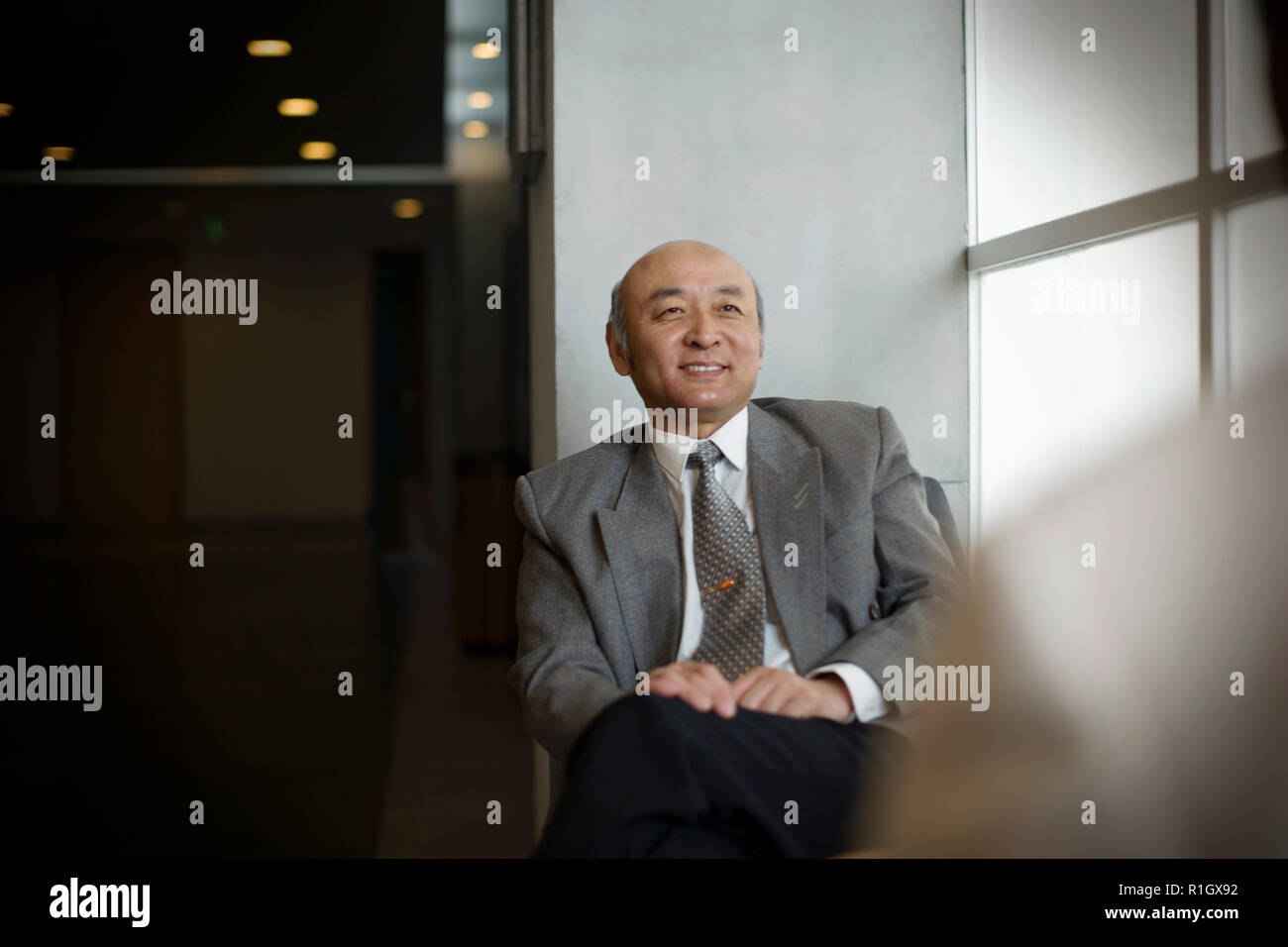 Senior adult man sitting in a room. Stock Photo