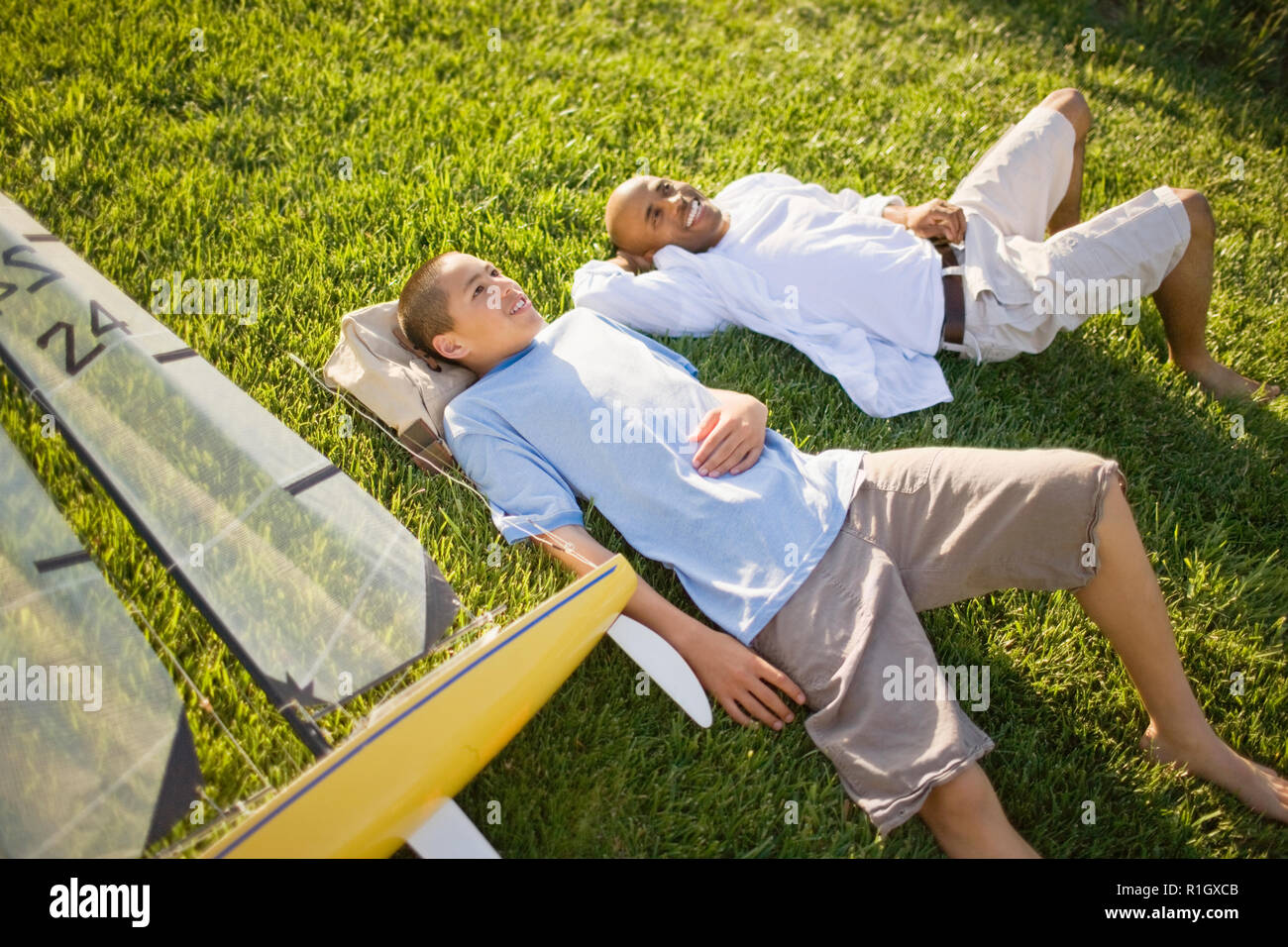 Father and son lying on the grass Stock Photo