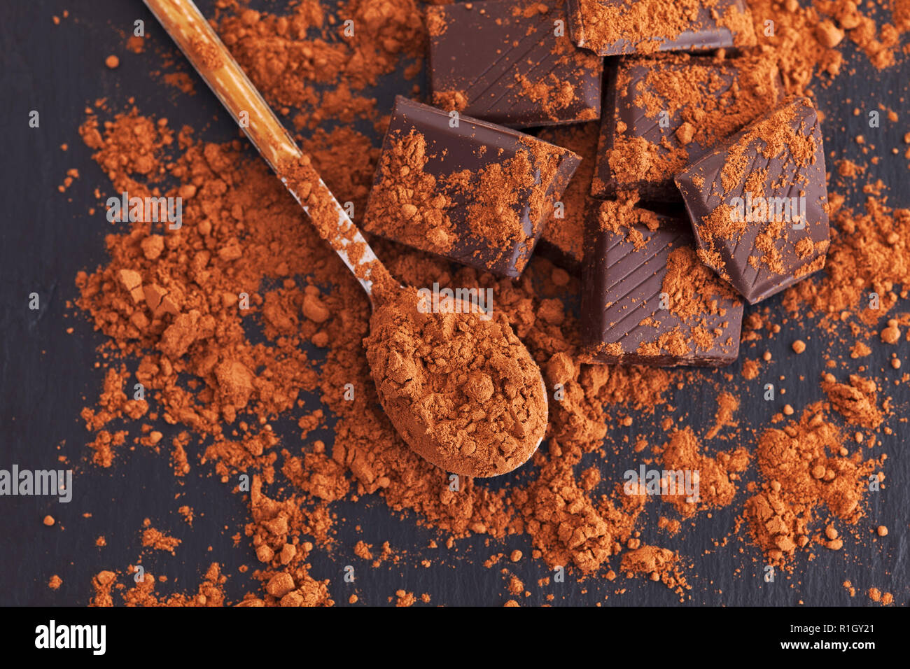 Broken dark chocolate with cocoa powder. Close up Stock Photo Alamy