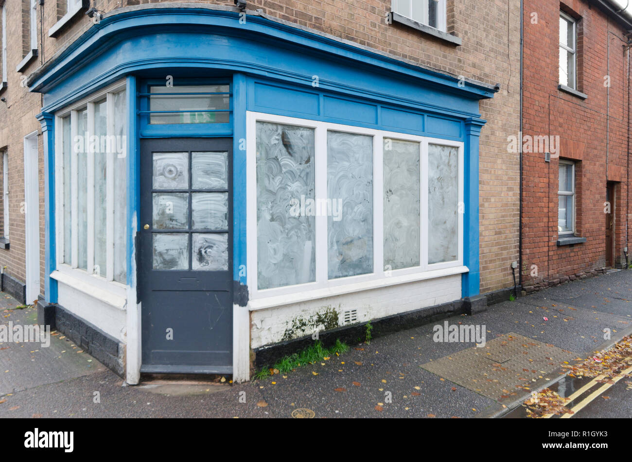 Traditional corner shop out of business closed with windows whitewashed. Stock Photo