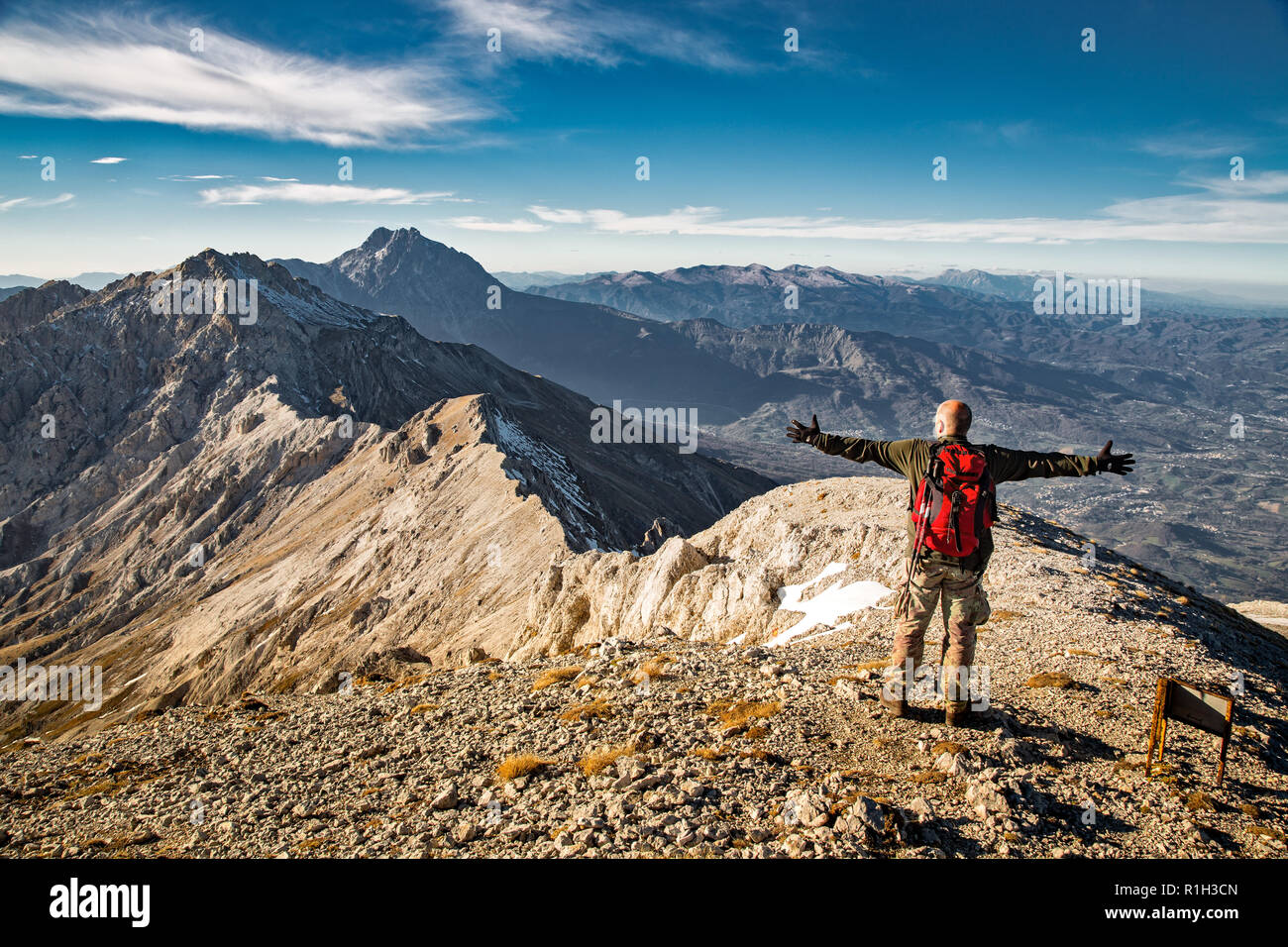High achiever, man standing with raised hands on top of mountain Camicia. .Abruzzo Stock Photo
