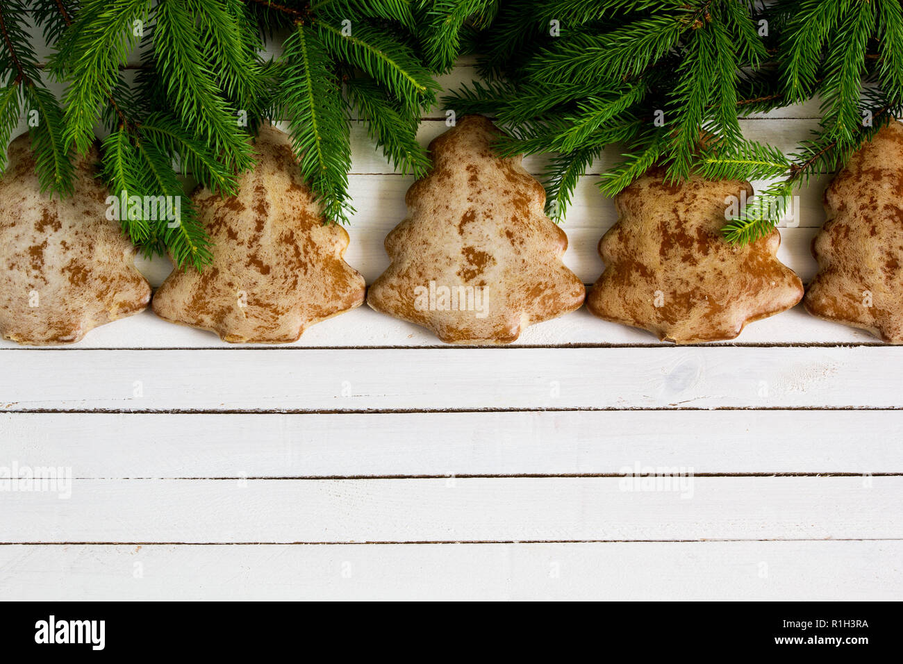 Gingerbread cookies and christmas tree branches on wooden background Stock Photo