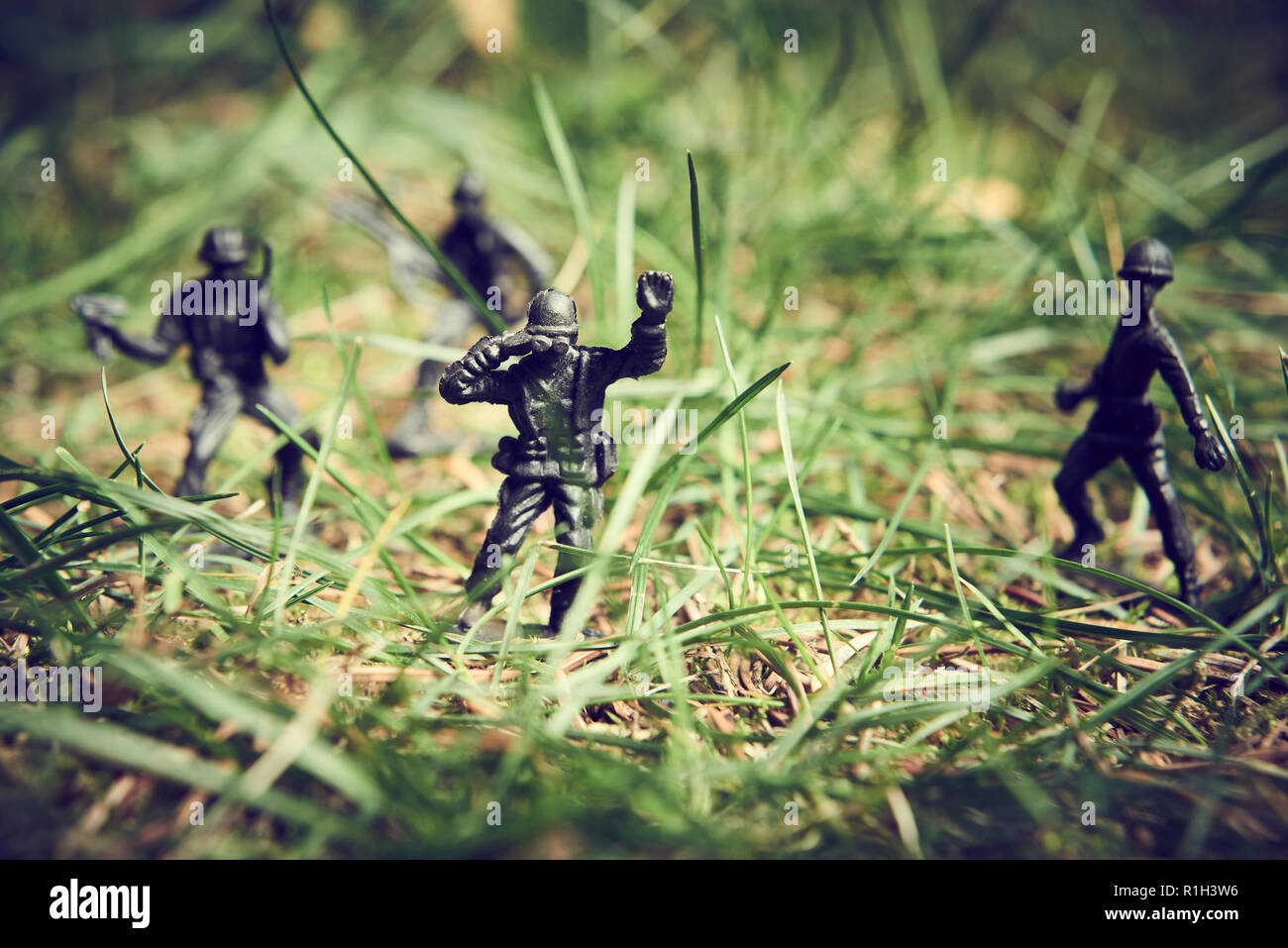 Soldiers in jungle fighting. Concept image of toy plastic soldiers in real grass.  Selective focus. Stock Photo