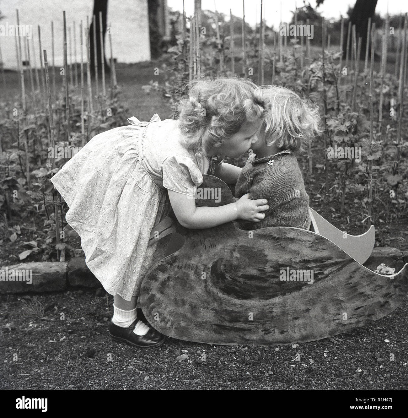 little girls garden sitting Two Little Girls in a Garden Harvesting Squashes. they are ...